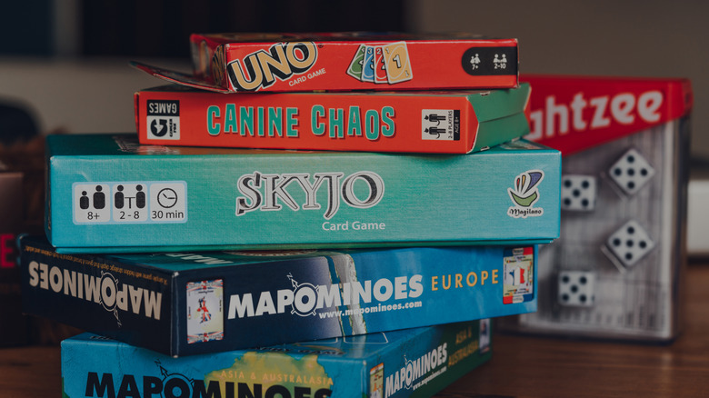 A pile of various board games sitting on a table