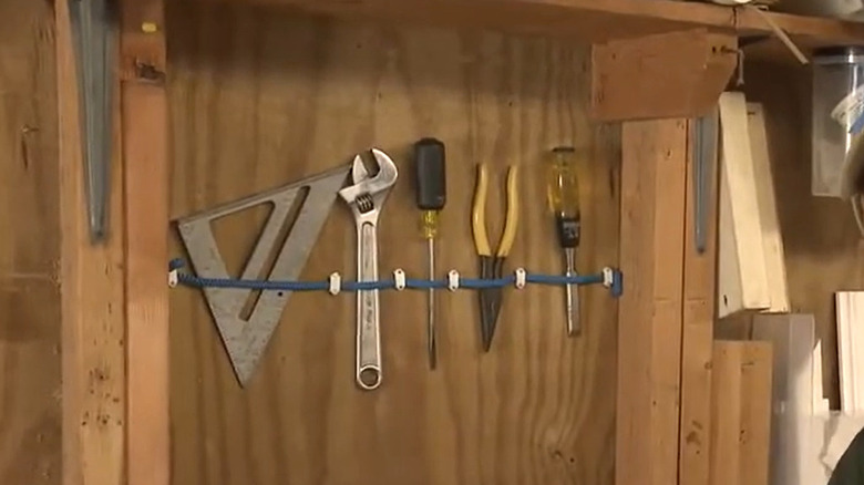 A bungee cord wall organizer with hand tools