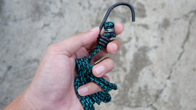 Person holding a green bungee cord