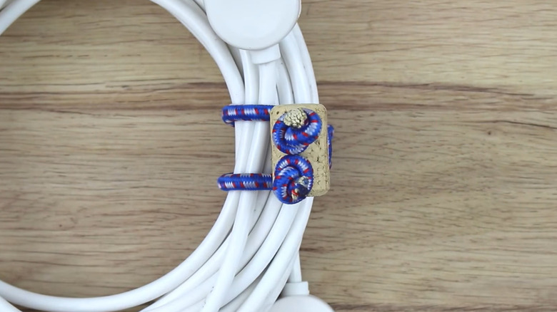 A bungee cord organizer tied around a long cable