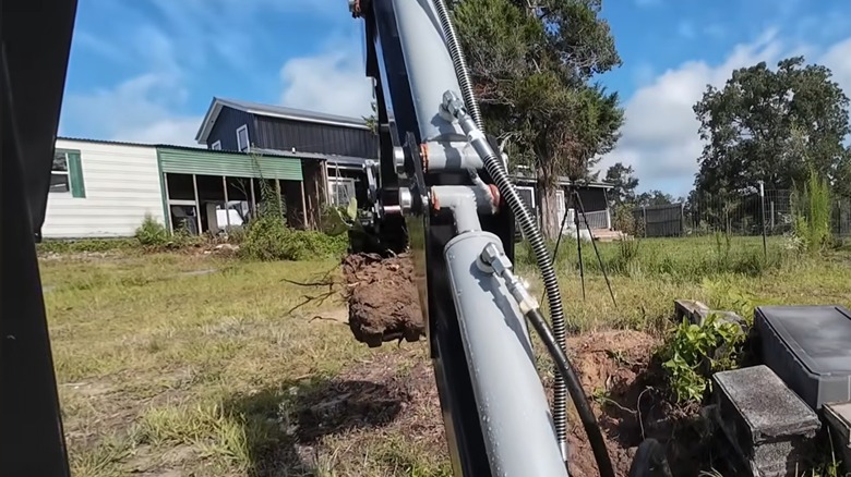 Person working on yard with Harbor Freight backhoe