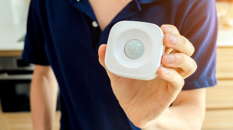 a person holding a smart motion sensor