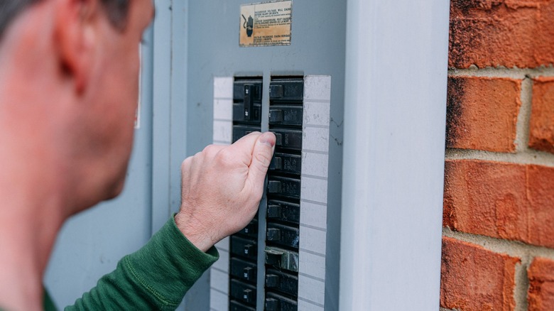 Man turning off a Circuit Breaker