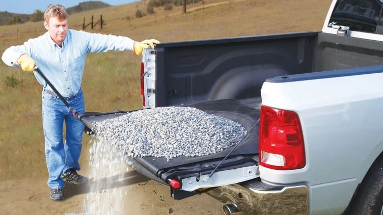 Person cranking gravel off truck bed