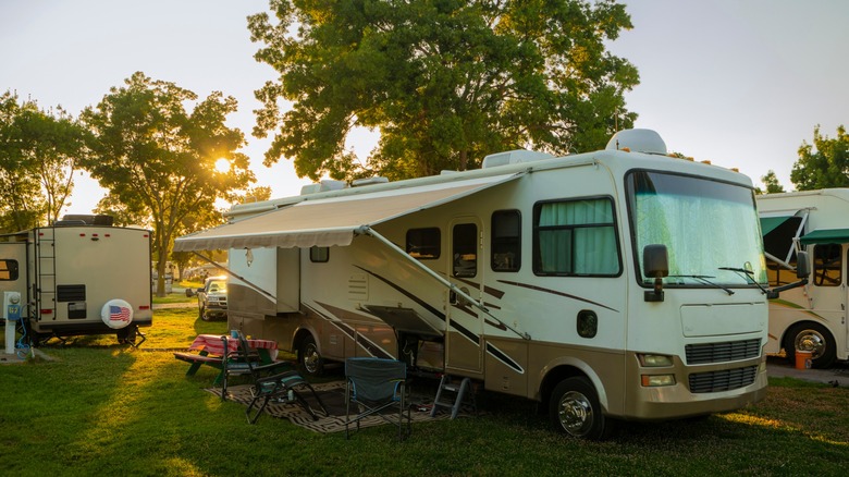 Rv parked in the grass with other RVs around