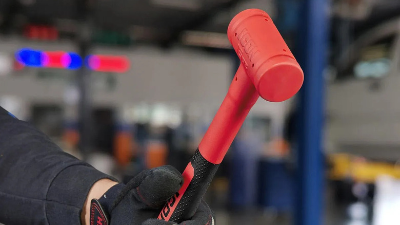 man holding dead blow hammer