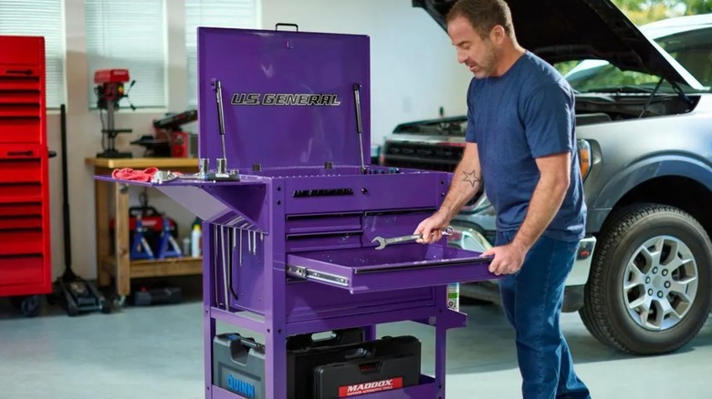 A person opening a U.S. General tool cart's drawer.