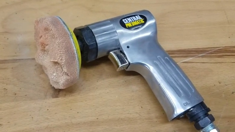 A Central Pneumatic polisher on a wood table.