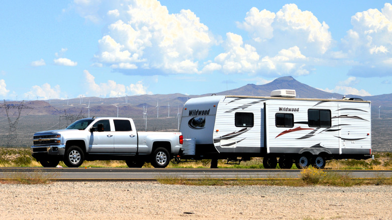 A Chevy truck towing a trailer through the desert