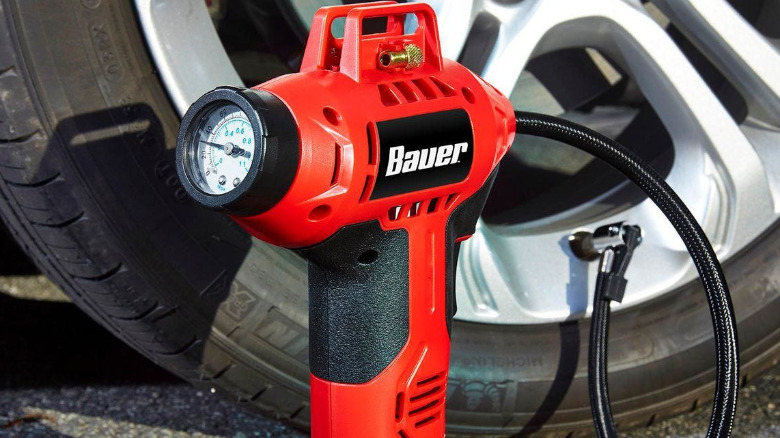 The Bauer 20V handheld inflator connected to a car tire.