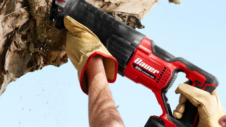 A person using a Bauer Reciprocating Saw on a tree.