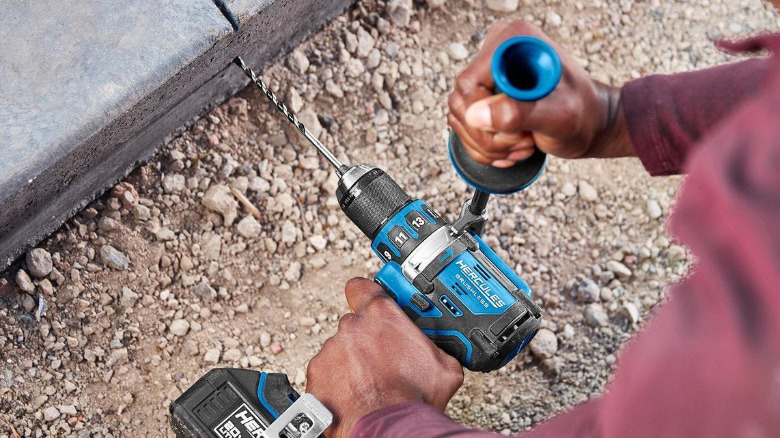 A person using a Hercules hammer drill on concrete.