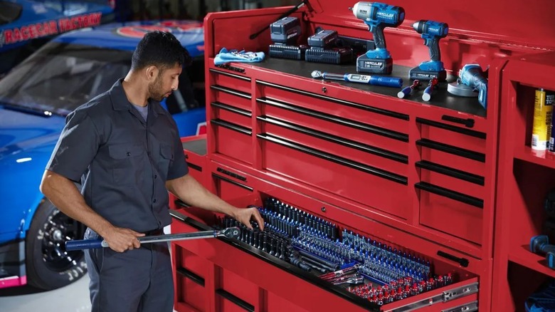 mechanic next to large roll cab