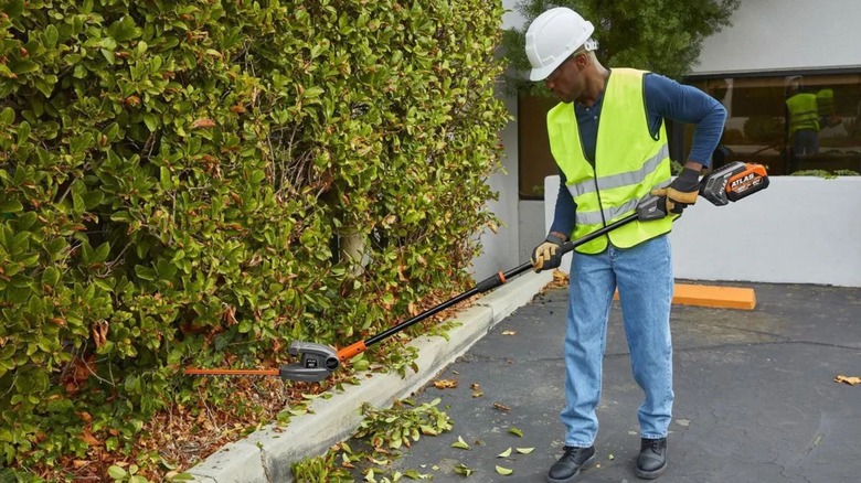 Man using Atlas 20-Inch Pole Hedge Trimmer