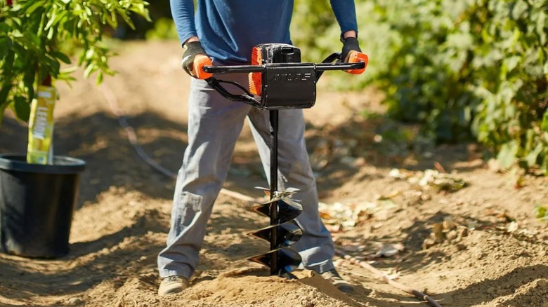 Man using Atlas Auger to drill hole
