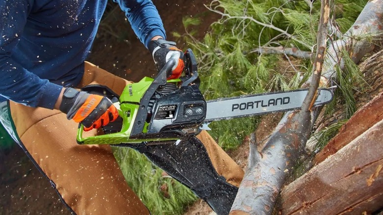Man using Portland 18-Inch Chainsaw to cut branch
