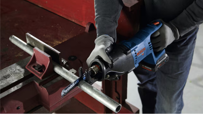 man using reciprocating on pipe