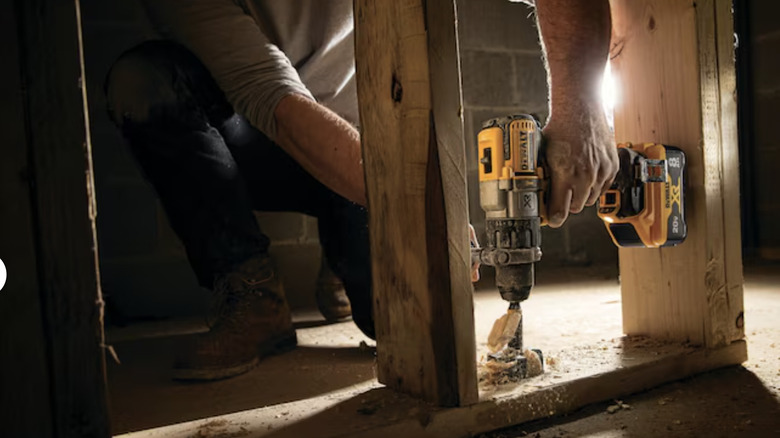 man using hammer drill on wood