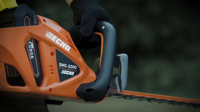 close-up of a person using an Echo DHC-2300 hedge trimmer