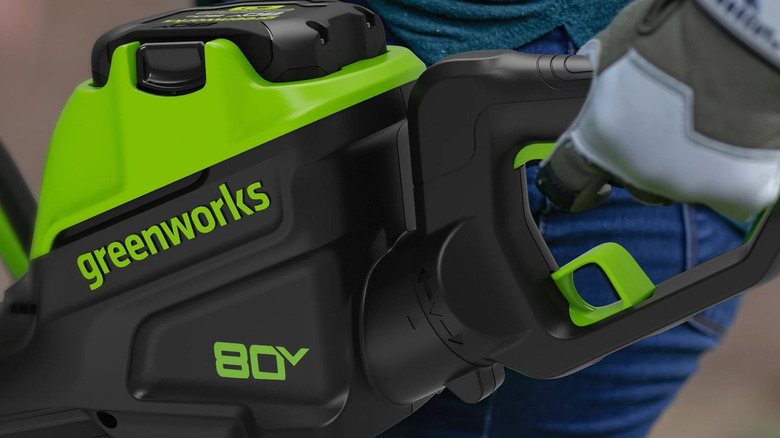 close-up of a person using a Greenworks 80V 26-inch hedge trimmer
