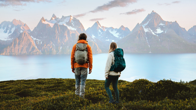 Two backpackers looking at mountains across a lake