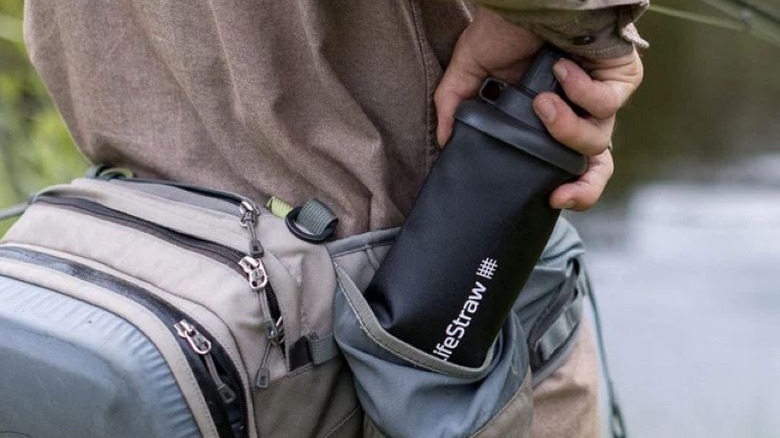 close up of water bottle being placed in hip bag