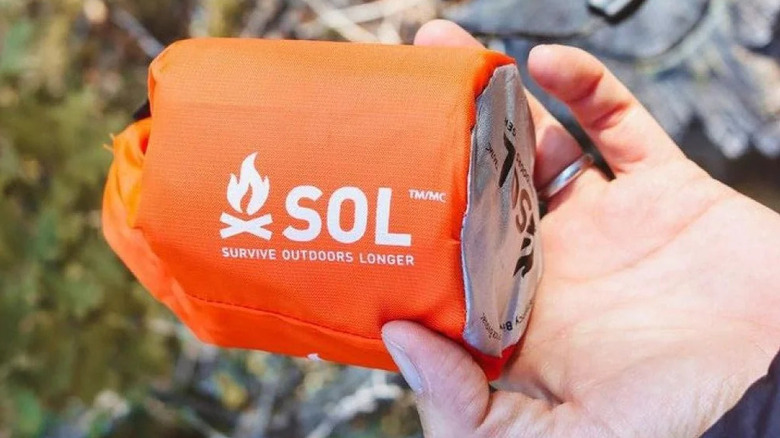 Hand holding a small orange pouch