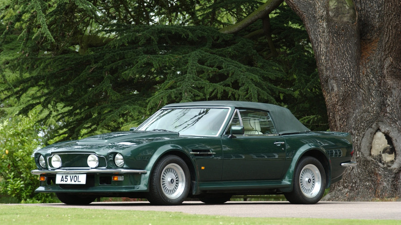 Green 1978 Aston Martin V8 Vantage Volante parked under tree