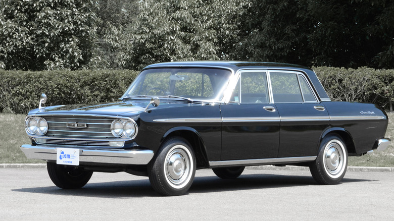 Black 1964 Toyota Crown Eight parked in front of greenery