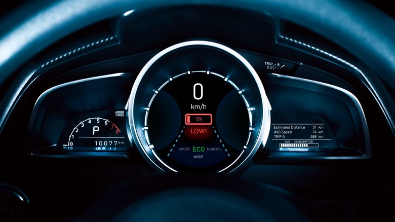 Rendering of an EV instrument cluster showing a low battery warning.