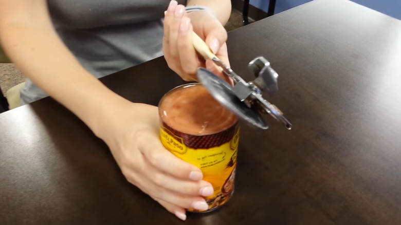 A girl opening a can of refried beans