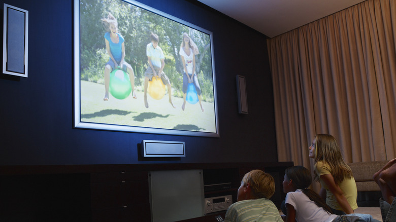 kids looking at photos on tv
