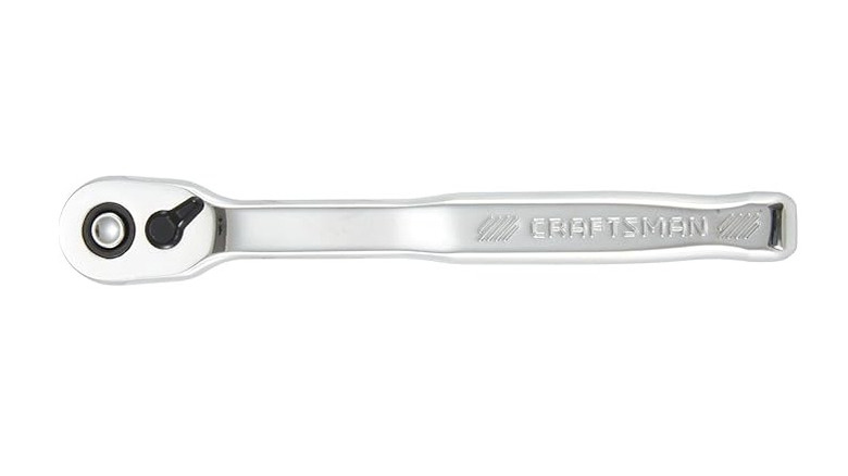 A silver ratchet on its side with a white background