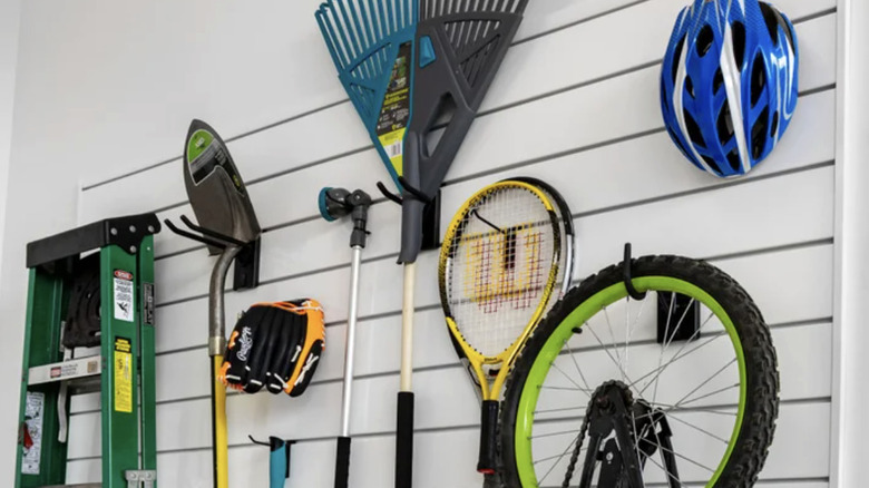 The Proslat Slatwall Kit assembled with a rake, a bicycle, a ladder and other items hanging from it