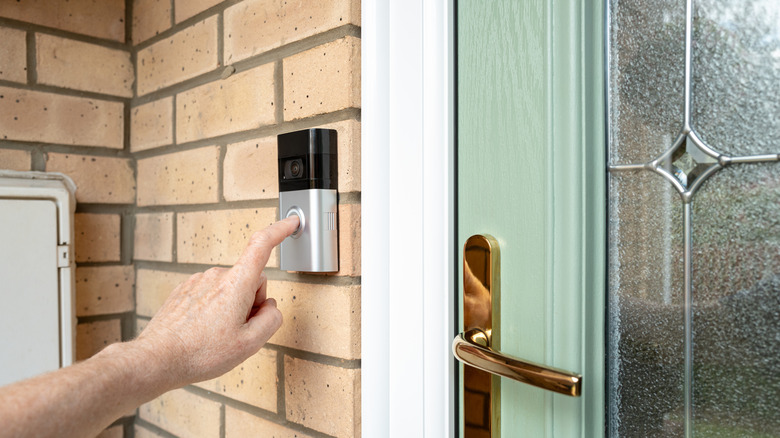person pressing ring doorbell