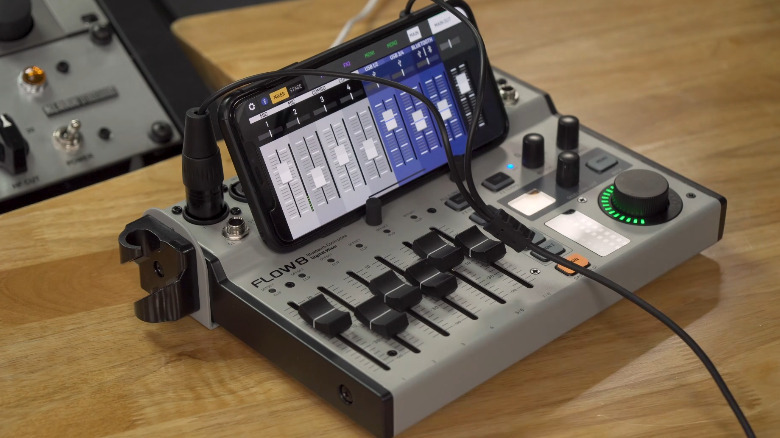 The Behringer Flow 8 and a phone displaying the companion app on a table.