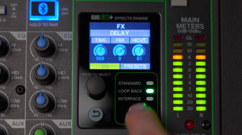 A person adjustes the internal effects on a Mackie ProFX12v3 Plus.