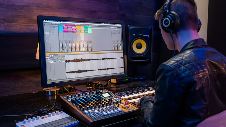A person uses a Tascam Model 12 in front of a computer.