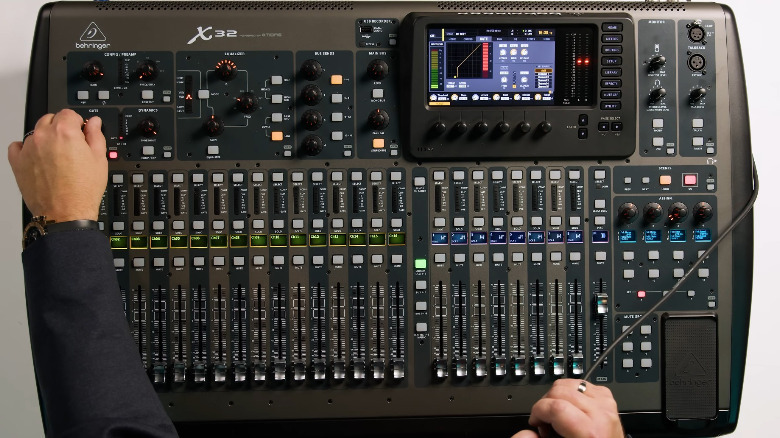 A person using an incredibly large full-size Behringer X32.