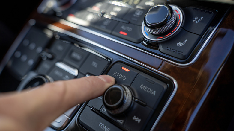 Driver adjusting car radio