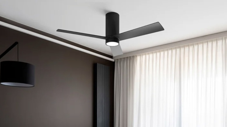 A black Atomi Smart Nouvo 3 ceiling fan mounted on a white ceiling in a modern room