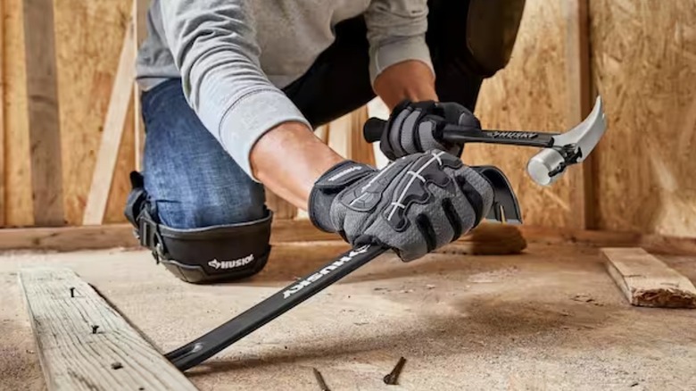Person using Husky hammer and pry bar on a work site