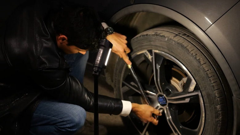 Driver using a Husky tripod work light while changing a flat tire
