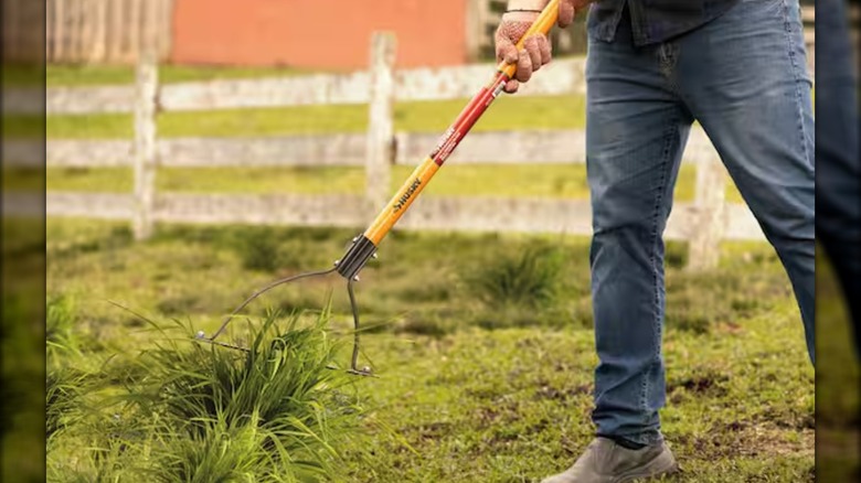 A Husky 30-Inch Double Blade Weed Cutter being used to clear brush on a farm