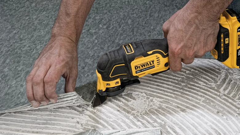 DIYer using a DeWalt Atomic 20V Max oscillating multi-tool