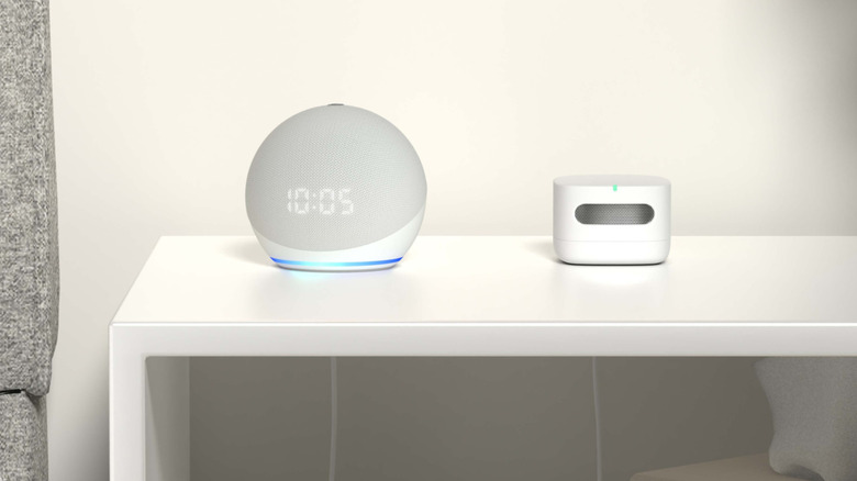 An Amazon Smart Air Quality Monitor placed next to an Amazon Echo Dot on a table.