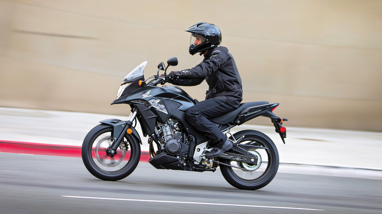 Side view of a Honda CB500X being driven on a city road