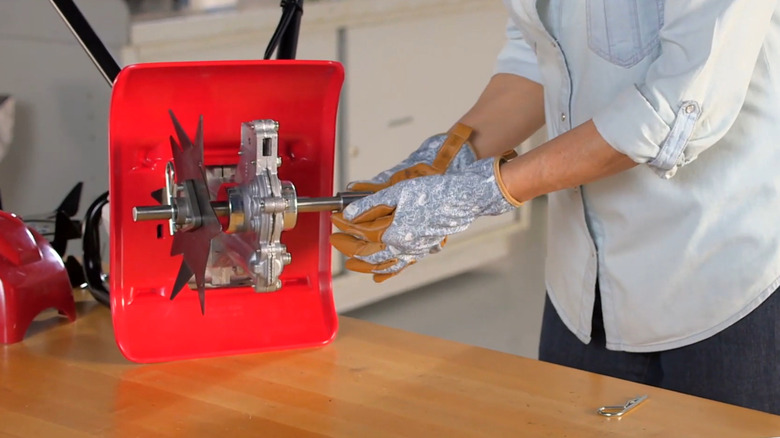 Person installing an edger kit on the FG110 tiller.