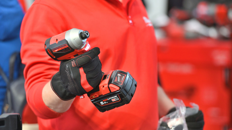 Milwaukee employee holding an impact driver