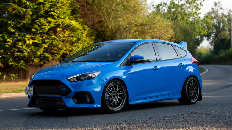 A blue Ford Focus RS parked in the middle of a road.